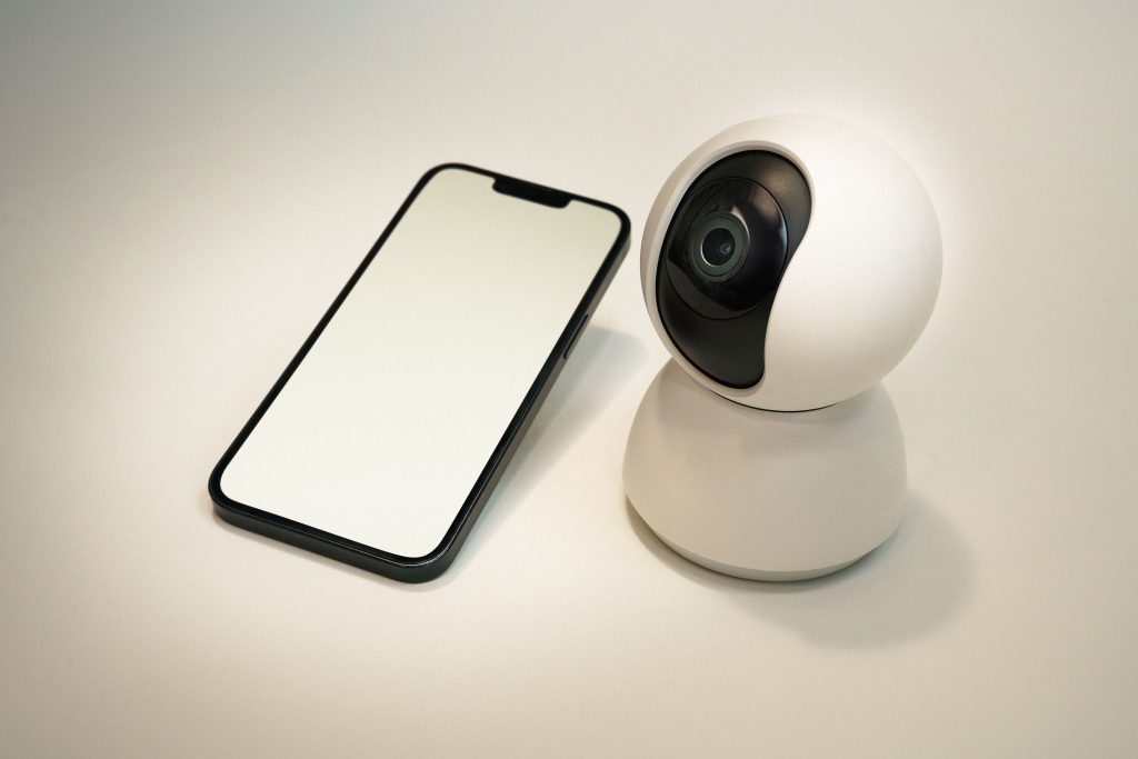 phone lying next to a small spy camera representing phone surveillance